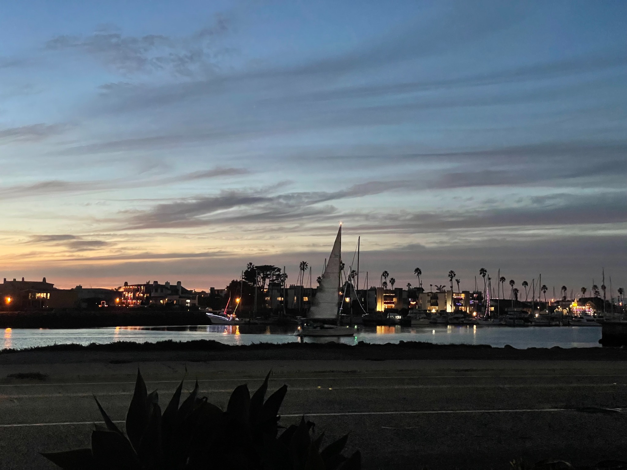 Sailboats and waterfront lights at dusk in Channel Islands Harbor