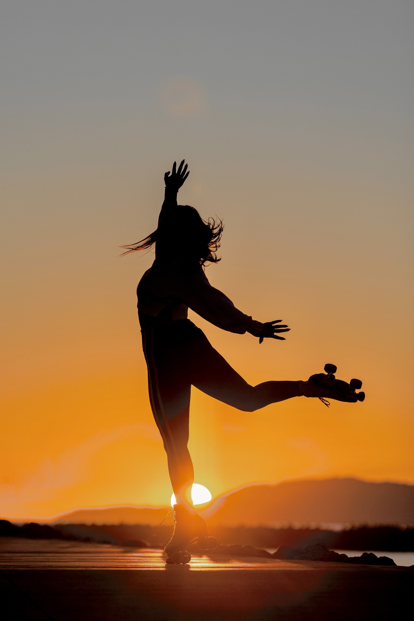 A roller skater silhouetted against the sunset